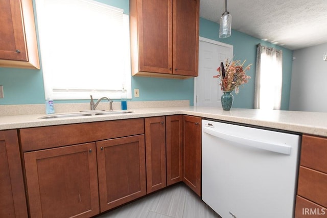 kitchen with sink, light tile patterned floors, dishwasher, a textured ceiling, and decorative light fixtures