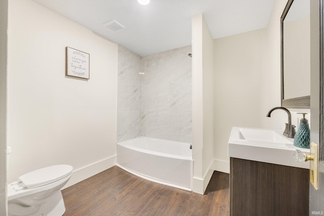 full bathroom featuring hardwood / wood-style flooring, vanity, toilet, and tiled shower / bath combo