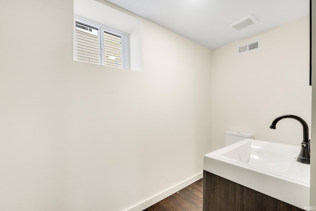 laundry room featuring sink and dark wood-type flooring