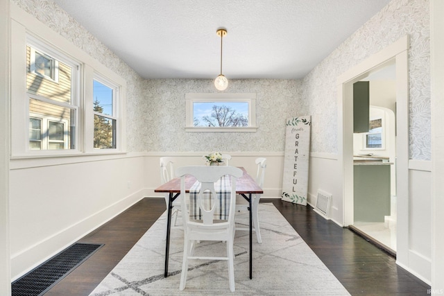 dining room with dark wood-type flooring and a textured ceiling