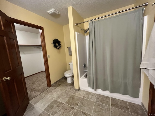 bathroom featuring shower / bath combo, toilet, and a textured ceiling