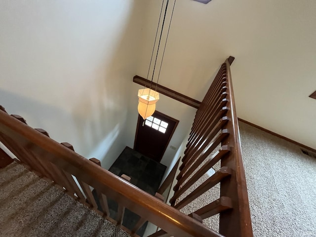 stairs featuring a towering ceiling and carpet