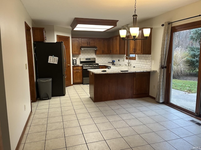 kitchen with decorative backsplash, hanging light fixtures, light tile patterned floors, kitchen peninsula, and stainless steel appliances