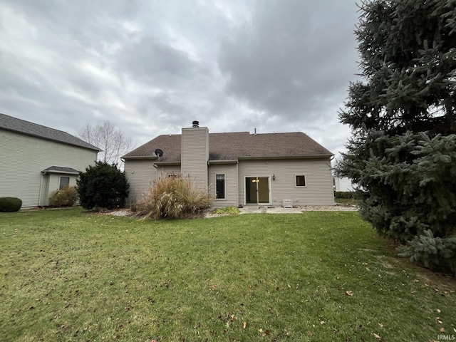 rear view of house with a patio and a yard