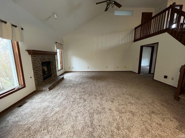 unfurnished living room with ceiling fan, a fireplace, vaulted ceiling, and carpet