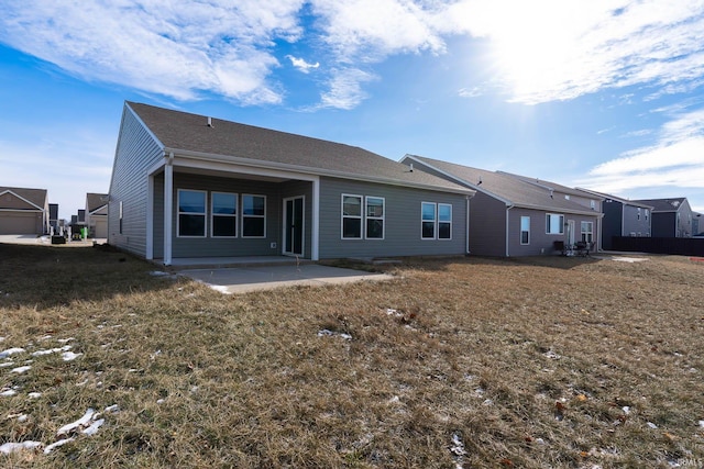 rear view of property with a lawn and a patio area