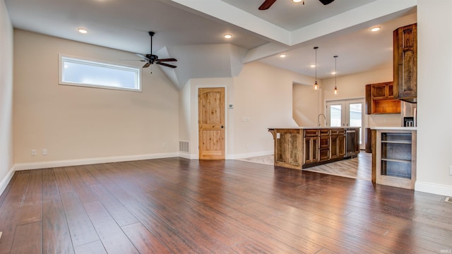 unfurnished living room featuring dark wood-type flooring and ceiling fan