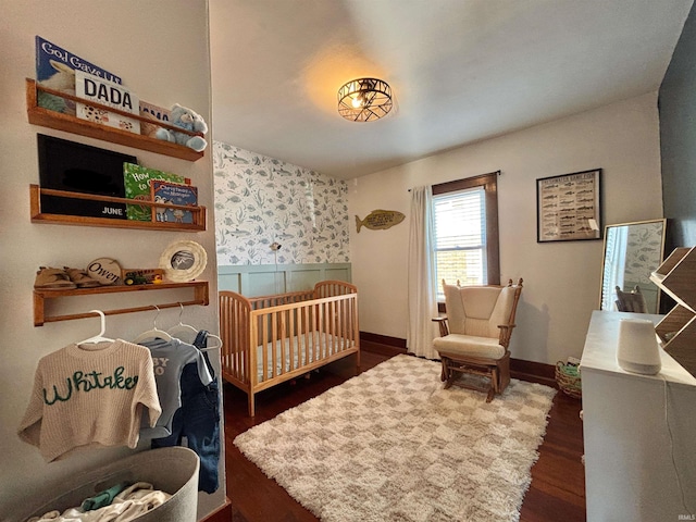 bedroom featuring dark hardwood / wood-style flooring and a nursery area