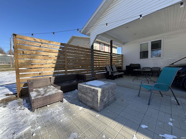 view of patio with an outdoor living space with a fire pit