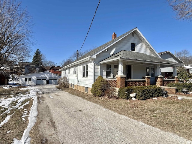 view of front facade with an outbuilding, a garage, and covered porch