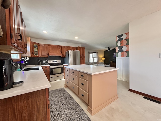 kitchen featuring a kitchen island, appliances with stainless steel finishes, sink, decorative backsplash, and ceiling fan