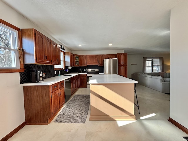 kitchen featuring sink, a breakfast bar area, appliances with stainless steel finishes, a kitchen island, and decorative backsplash