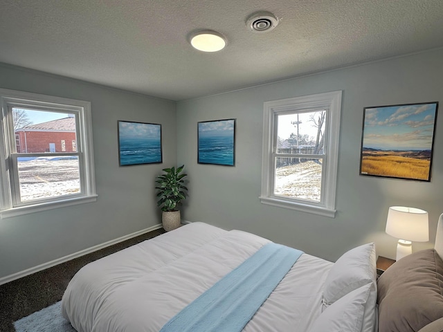 bedroom with dark carpet and a textured ceiling