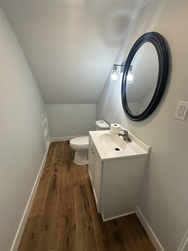 bathroom with vanity, toilet, hardwood / wood-style floors, and a textured ceiling