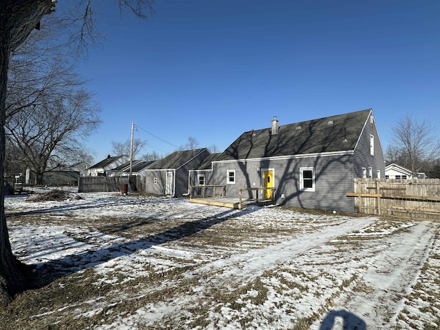 snow covered rear of property with a wooden deck