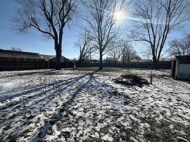 snowy yard featuring fence
