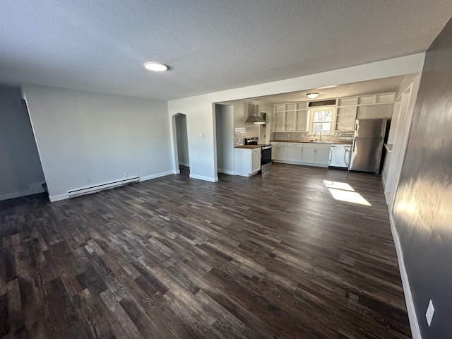 unfurnished living room featuring sink, dark wood-type flooring, a textured ceiling, and baseboard heating