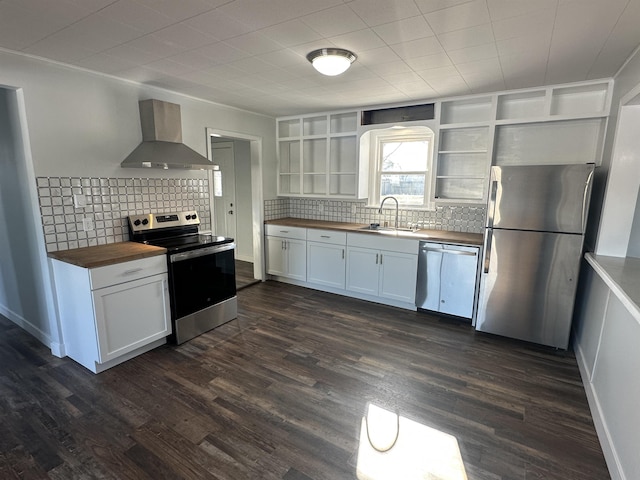 kitchen with sink, appliances with stainless steel finishes, butcher block counters, white cabinetry, and wall chimney exhaust hood