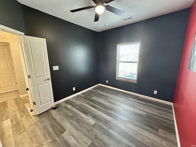 spare room featuring ceiling fan, light hardwood / wood-style flooring, and a textured ceiling