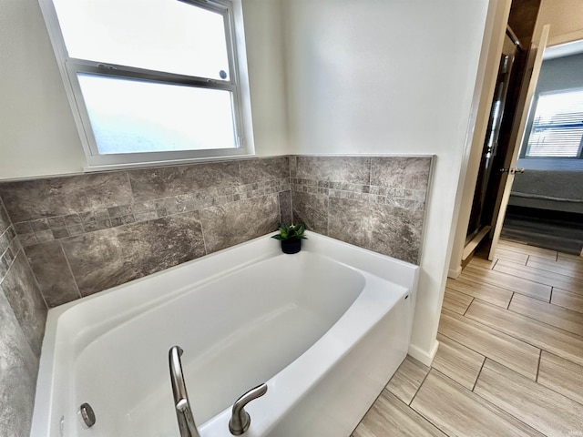 bathroom featuring a tub and a wealth of natural light