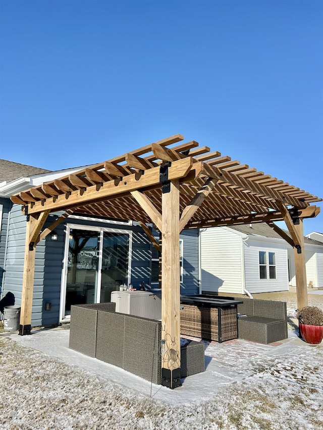 snow covered patio with outdoor lounge area and a pergola