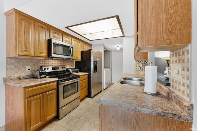 kitchen with stainless steel appliances, sink, light tile patterned floors, and backsplash