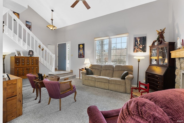 carpeted living room with ceiling fan and vaulted ceiling