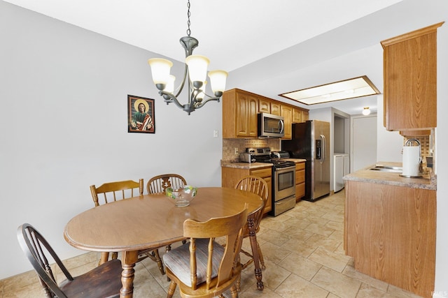 dining space with sink and a notable chandelier