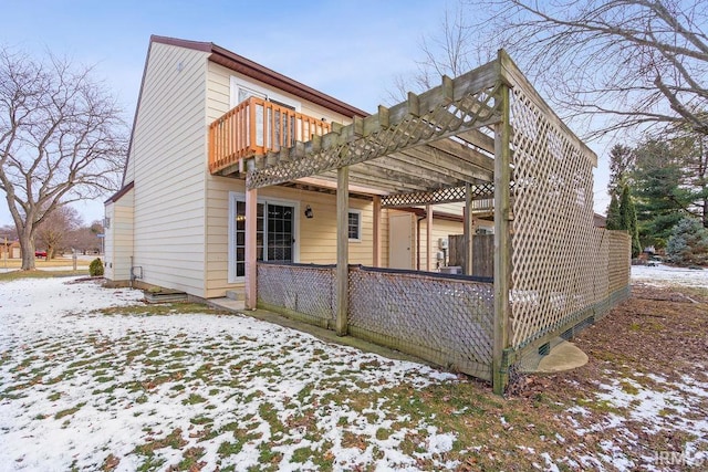 view of snow covered exterior with a balcony and a pergola