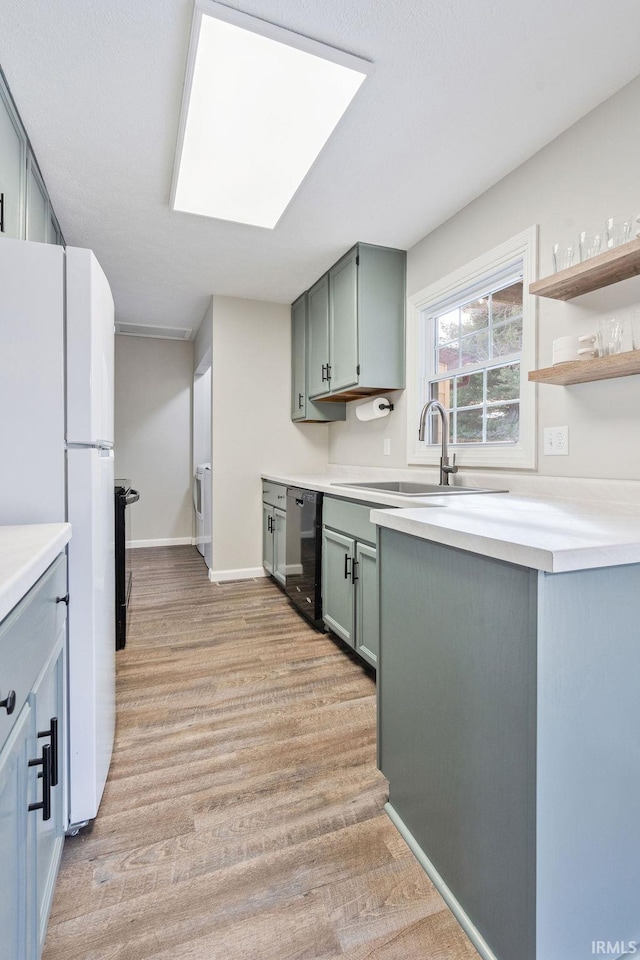 kitchen featuring white refrigerator, dishwasher, sink, and light hardwood / wood-style flooring