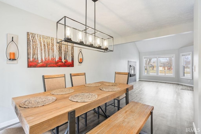 dining room featuring lofted ceiling with beams, hardwood / wood-style flooring, and a chandelier