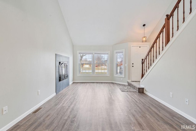 unfurnished living room with high vaulted ceiling and hardwood / wood-style floors