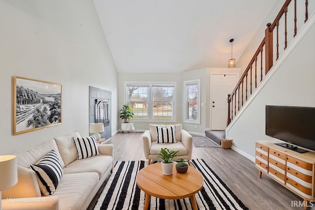 living room with high vaulted ceiling and light hardwood / wood-style flooring