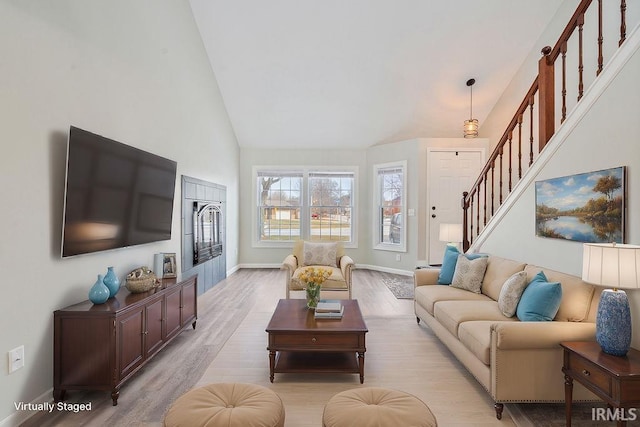 living room featuring light hardwood / wood-style flooring and high vaulted ceiling