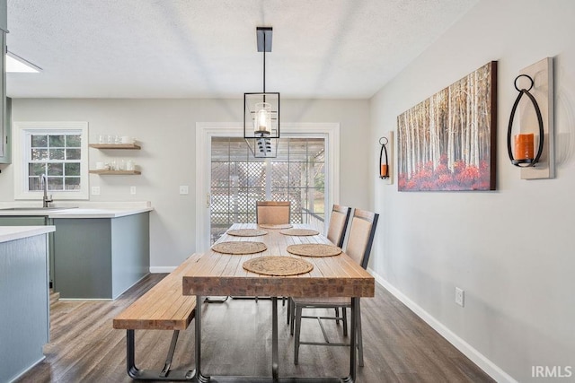 dining area with dark hardwood / wood-style flooring, sink, and a textured ceiling