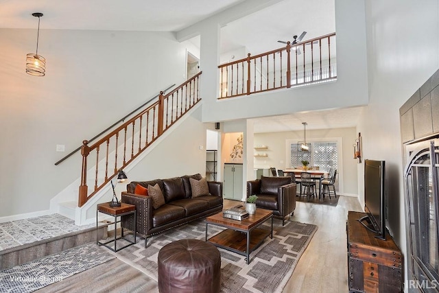 living room featuring ceiling fan, wood-type flooring, and high vaulted ceiling