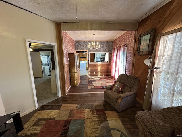 living room with brick wall, wooden walls, a textured ceiling, and a notable chandelier