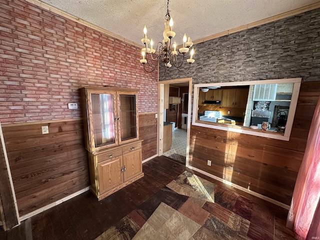 unfurnished dining area featuring dark hardwood / wood-style floors, a notable chandelier, and a textured ceiling