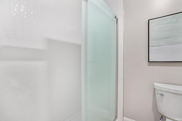 bathroom featuring toilet and a tile shower