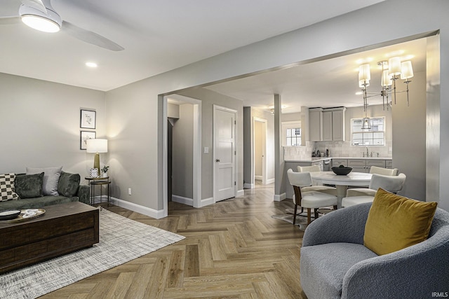 living room with ceiling fan, light parquet flooring, and sink