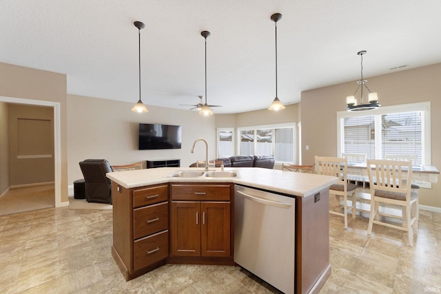 kitchen featuring sink, hanging light fixtures, a center island with sink, stainless steel dishwasher, and a wealth of natural light