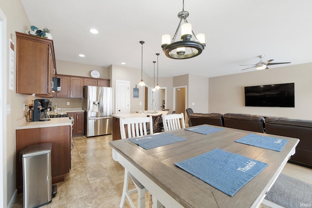 dining room with sink and ceiling fan with notable chandelier