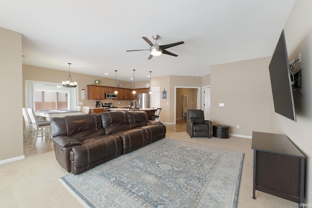 living room with light carpet and ceiling fan with notable chandelier