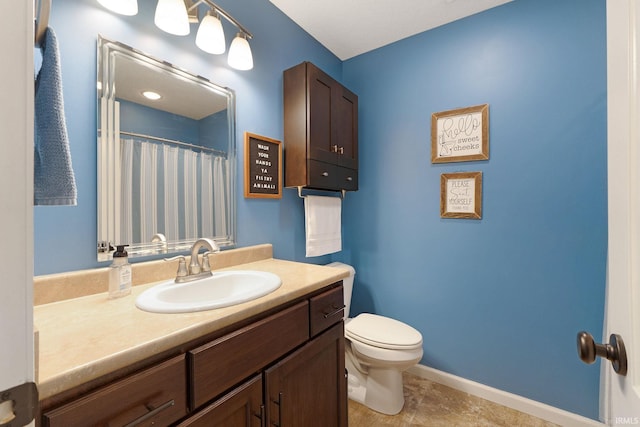 bathroom with vanity, toilet, and curtained shower