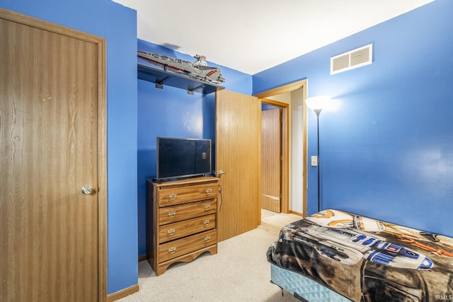 bedroom featuring light colored carpet and a closet