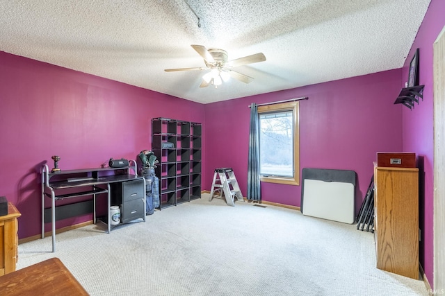 carpeted office with a textured ceiling and ceiling fan