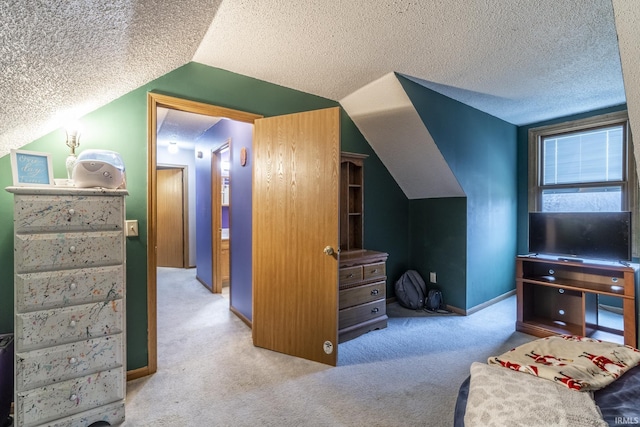 carpeted bedroom with vaulted ceiling and a textured ceiling