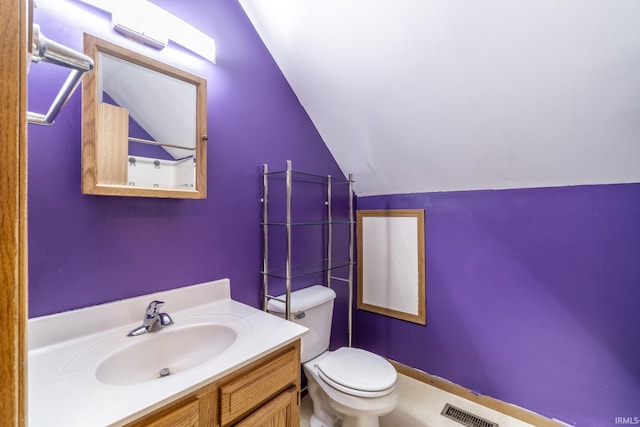 bathroom featuring vanity, lofted ceiling, and toilet