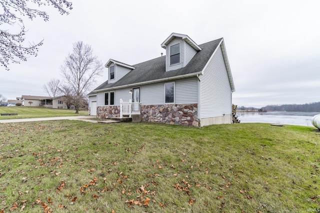 new england style home featuring a front yard and a water view