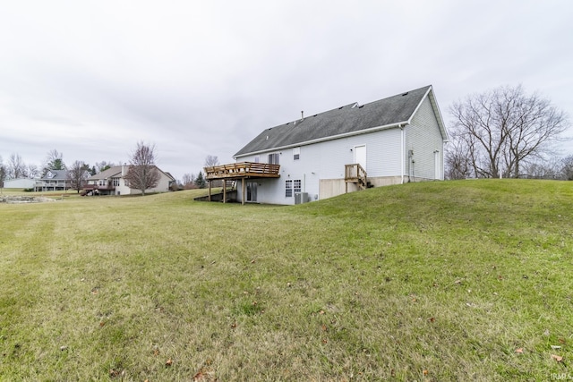 back of house with a wooden deck and a lawn